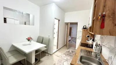 a kitchen with a sink and a table and a counter at Grajski kamen apartment in Maribor