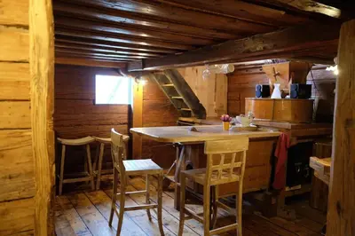 a kitchen with a table and chairs in a cabin at Wooden love nest in Vransko