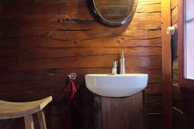 a bathroom with a sink in a wooden wall at Wooden love nest in Vransko
