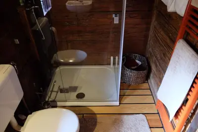 a small bathroom with a shower and a toilet at Wooden love nest in Vransko