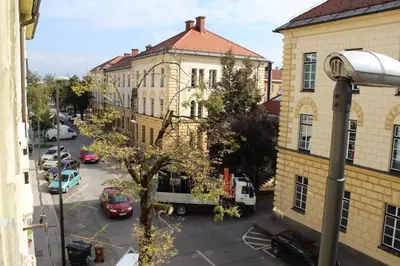 a city street with cars parked in front of buildings at Ljubljana City Apartment Metelkova in Ljubljana