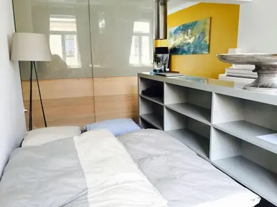 a room with a bed and a desk with shelves at Ljubljana City Apartment Metelkova in Ljubljana