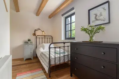 a bedroom with a bed and a dresser and a window at Villa Polje in Bohinj