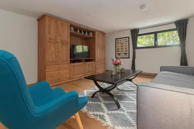 a living room with a couch and a table and a tv at Villa Polje in Bohinj