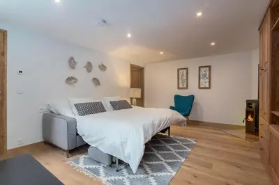 a bedroom with a bed and a blue chair at Villa Polje in Bohinj