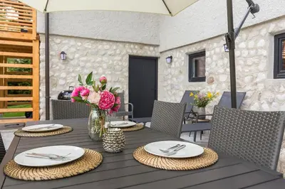 a wooden table with plates and flowers in a vase at Villa Polje in Bohinj
