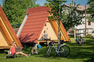 a group of people sitting in the grass with a bike at DS Camping in Grgar