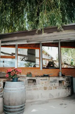 a building with windows and two barrels with flowers at DS Camping in Grgar