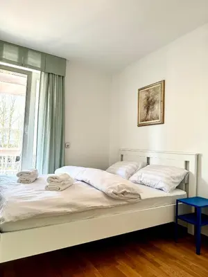 two beds in a white room with a window at Central Villa with Garden in Ljubljana