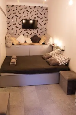 a bed in a room with a wall with birds on it at Lovely City Nest in Ljubljana