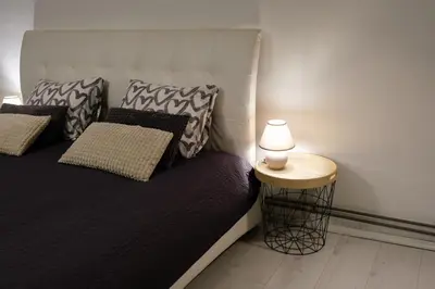 a bedroom with a bed with a lamp on a table at Lovely City Nest in Ljubljana
