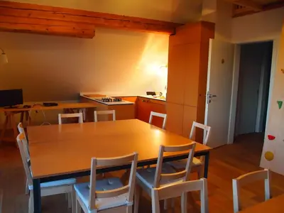 a kitchen with a wooden table and chairs at Bed & Breakfast Base Camp in Križe