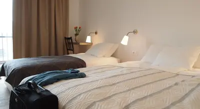 a hotel room with two beds and a bag on the bed at Bed & Breakfast Base Camp in Križe