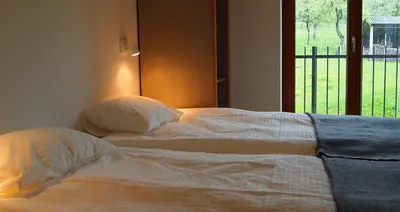 a bedroom with two beds and a window at Bed & Breakfast Base Camp in Križe