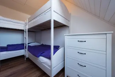 a bedroom with two bunk beds and a dresser at Holiday Home Planina in Tržič
