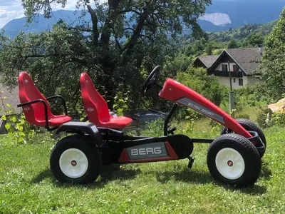 a red lawn mower sitting in the grass at Holiday Home Planina in Tržič