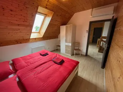 a bedroom with a large red bed in a attic at Holiday Home Planina in Tržič