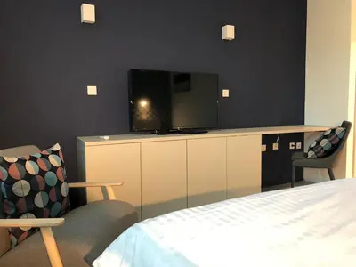 a bedroom with a bed and a flat screen tv at Hotel Cubis in Lendava