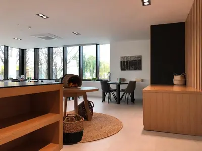 a kitchen and dining room with a table and windows at Hotel Cubis in Lendava