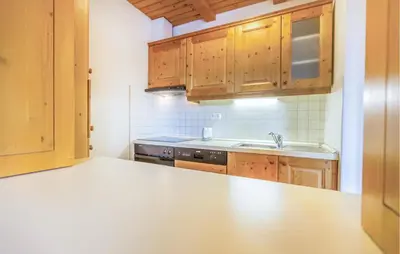 a kitchen with wooden cabinets and a counter top at 2 Bedroom Awesome Apartment In Pohorje in Pohorje