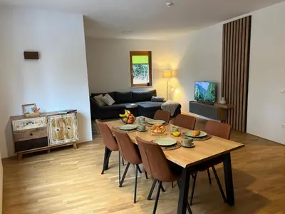 a living room with a table and chairs and a couch at Foxi apartment, Pohorje in Pohorje