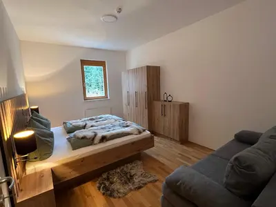 a bedroom with a bed and a couch at Foxi apartment, Pohorje in Pohorje