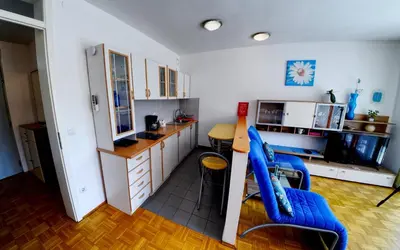 a kitchen with two blue chairs and a counter at Apartment Lent in Maribor