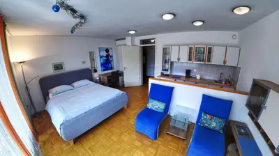 a bedroom with a bed and two blue chairs at Apartment Lent in Maribor