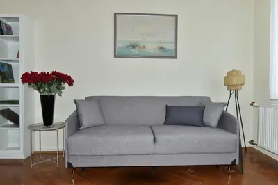 a couch in a living room with a vase of flowers at Apartment Joja in Ljubljana