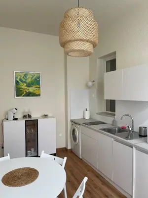 a kitchen with a white table and a kitchen with a sink at Apartment Joja in Ljubljana