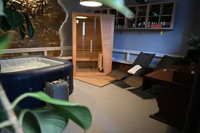 a room with a hot tub in a room with chairs at Hiša Štekar in Kojsko