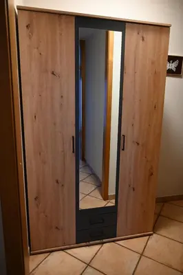 a mirror on a wooden door in a room at Hiša Štekar in Kojsko