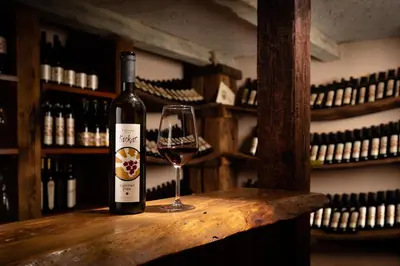 a bottle of wine sitting on a table with a glass at Hiša Štekar in Kojsko