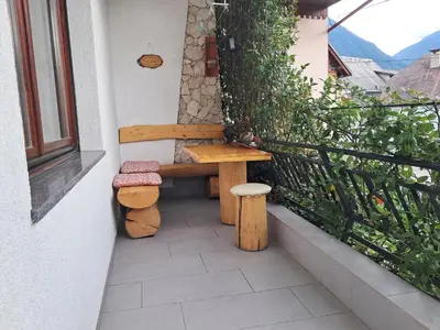 a wooden bench sitting on the side of a balcony at Apartment Norma in Bovec