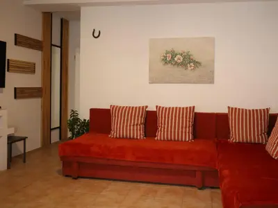 a living room with a red couch with two pillows at Apartment Norma in Bovec