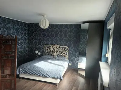 a bedroom with a bed and a blue wall at The Cottage in Murska Sobota