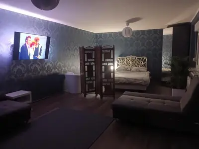 a living room with a couch and a tv on the wall at The Cottage in Murska Sobota