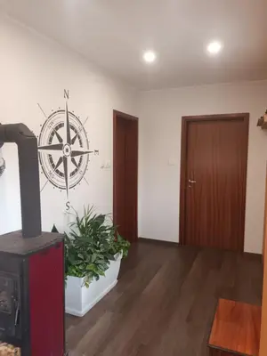 a living room with a stove and a wheel on the wall at The Cottage in Murska Sobota