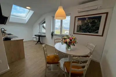 a dining room with a table and a vase of flowers at Apartmaji Čepon in Ljubljana
