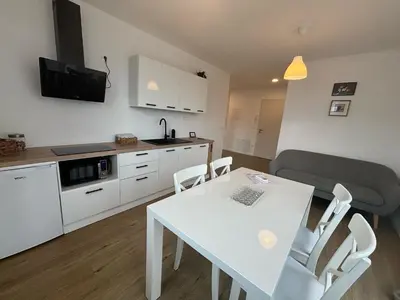 a kitchen and dining room with a white table and chairs at Apartmaji Čepon in Ljubljana