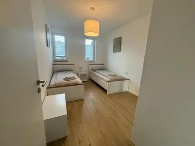 a room with two beds and a hallway with a door at Apartmaji Čepon in Ljubljana