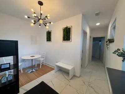 a living room with a table and a chandelier at Apartmaji Čepon in Ljubljana