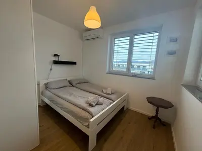 a small bedroom with a bed and a window at Apartmaji Čepon in Ljubljana