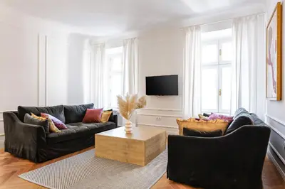 a living room with two black couches and a tv at MARIANNA'S OLD TOWN RESIDENCE in Ljubljana