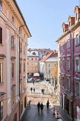 a group of people walking down a street between buildings at MARIANNA'S OLD TOWN RESIDENCE in Ljubljana