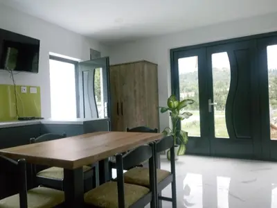 a dining room with a wooden table and chairs at TOMO 2 in Postojna