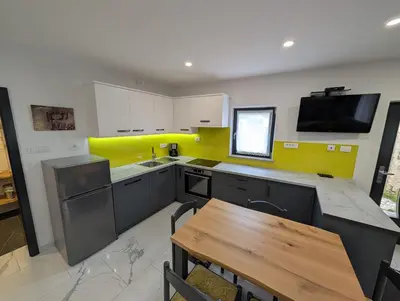 a kitchen with a table and a yellow wall at TOMO 2 in Postojna