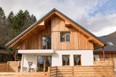 a wooden house with a gambrel roof at LARCH HOUSE in Cerklje na Gorenjskem