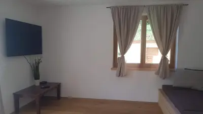 a living room with a window and a table at LARCH HOUSE in Cerklje na Gorenjskem