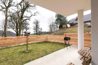a patio with a fence and a table and a bench at LARCH HOUSE in Cerklje na Gorenjskem